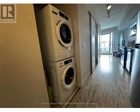 A Royal LePage Real Estate Associates brokerage logo is on a wall in a room with a washer and dryer stacked on top of each other.