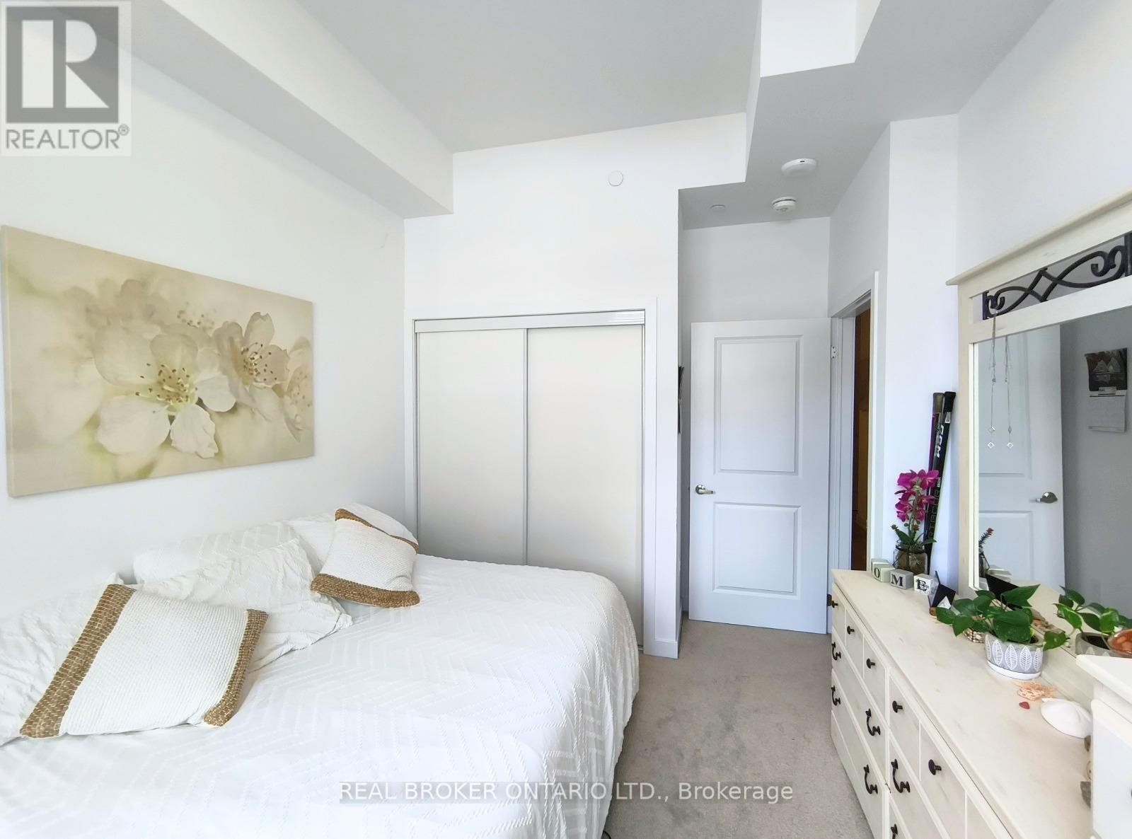 A bedroom with a large bed and a painting on the wall.