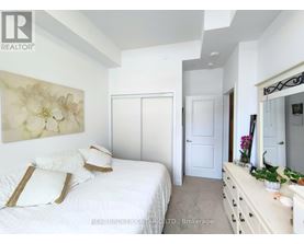 A bedroom with a large bed and a painting on the wall.