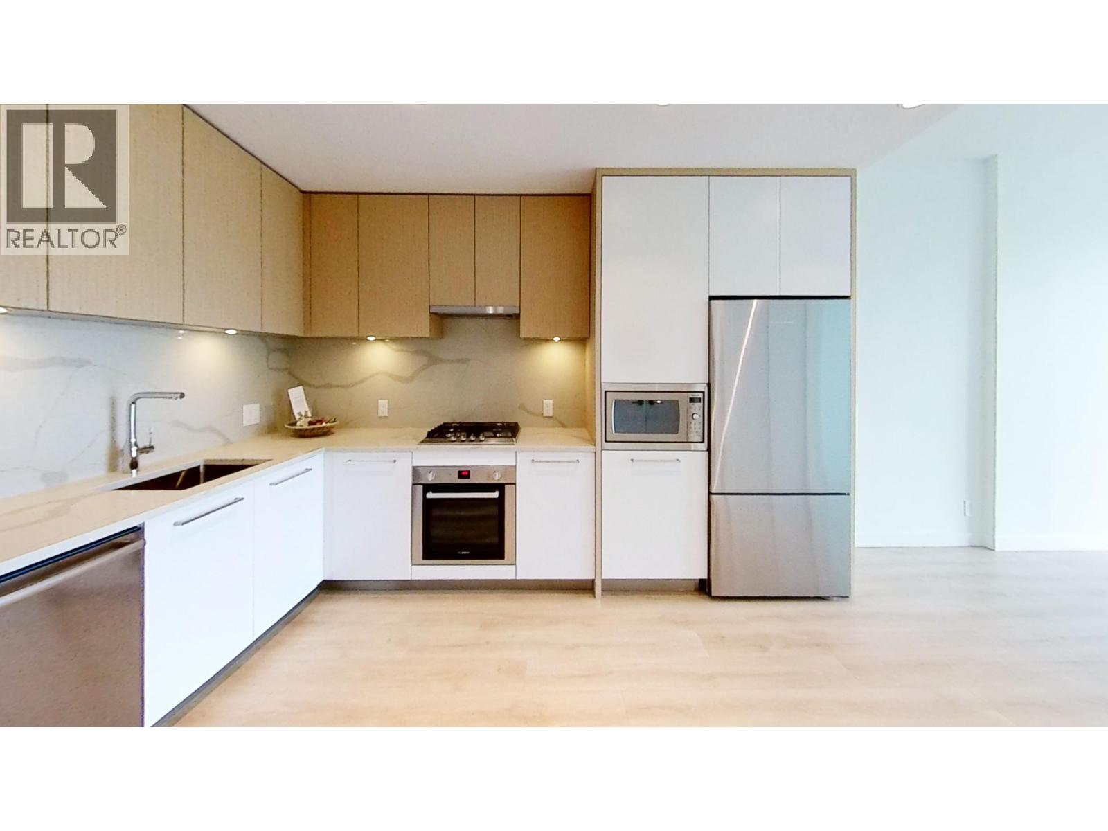 A modern kitchen with wooden cabinets and stainless steel appliances.