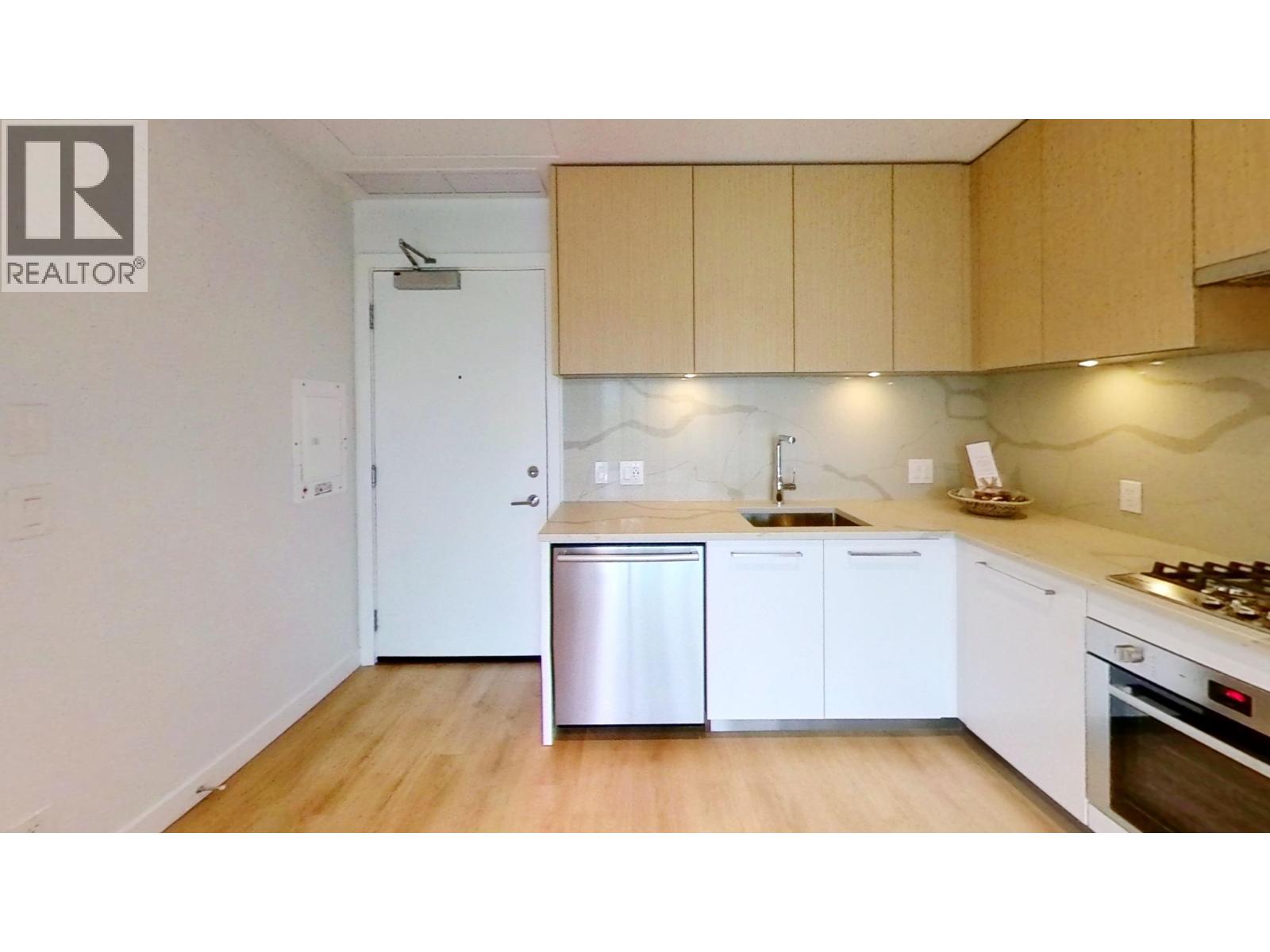 A kitchen with a dishwasher, sink, and stove top oven.