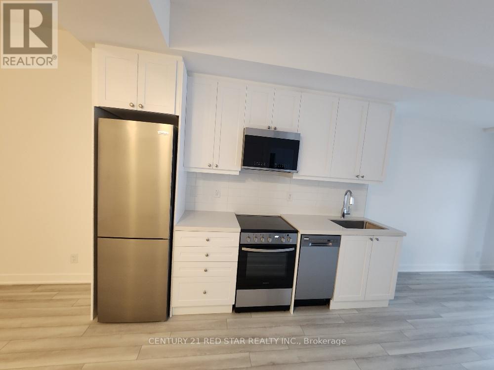 A modern kitchen with white cabinets and stainless steel appliances.
