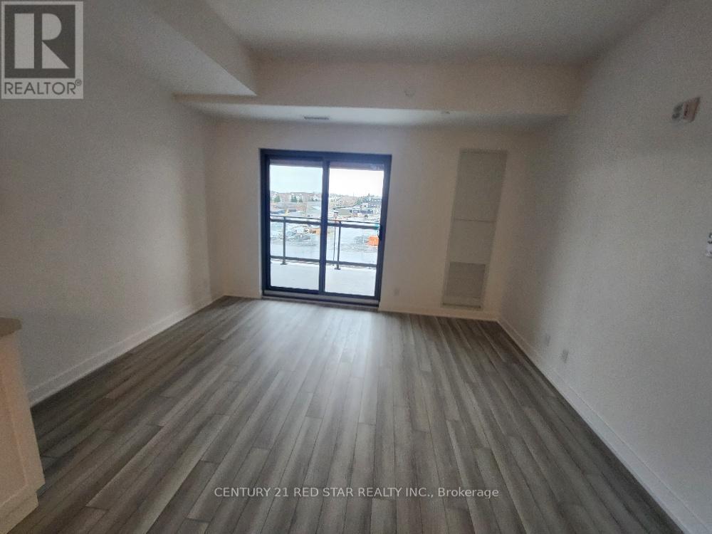 A room with wooden flooring and a large window overlooking a cityscape.