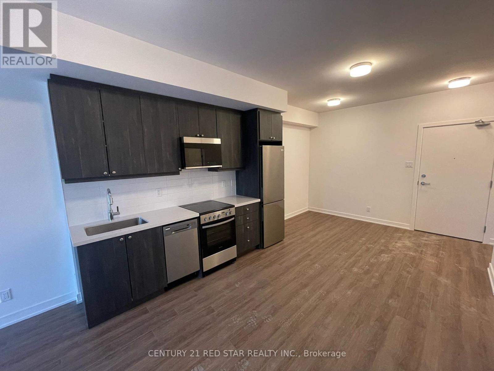 A kitchen with black cabinets and stainless steel appliances.