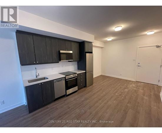 A kitchen with black cabinets and stainless steel appliances.