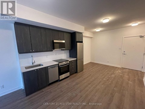 A kitchen with black cabinets and stainless steel appliances.