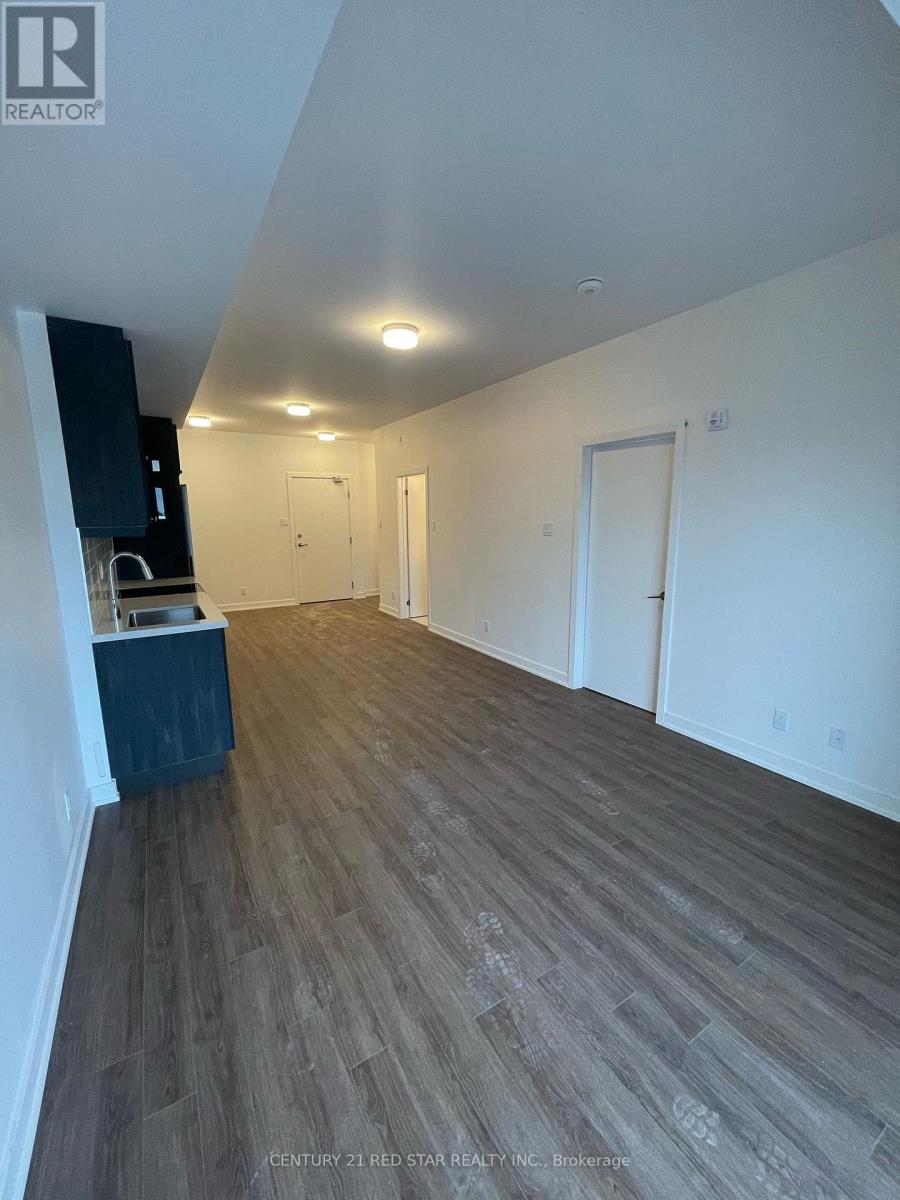 A spacious room with wooden flooring and white walls.