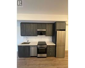 A modern kitchen with dark wood cabinets and stainless steel appliances.