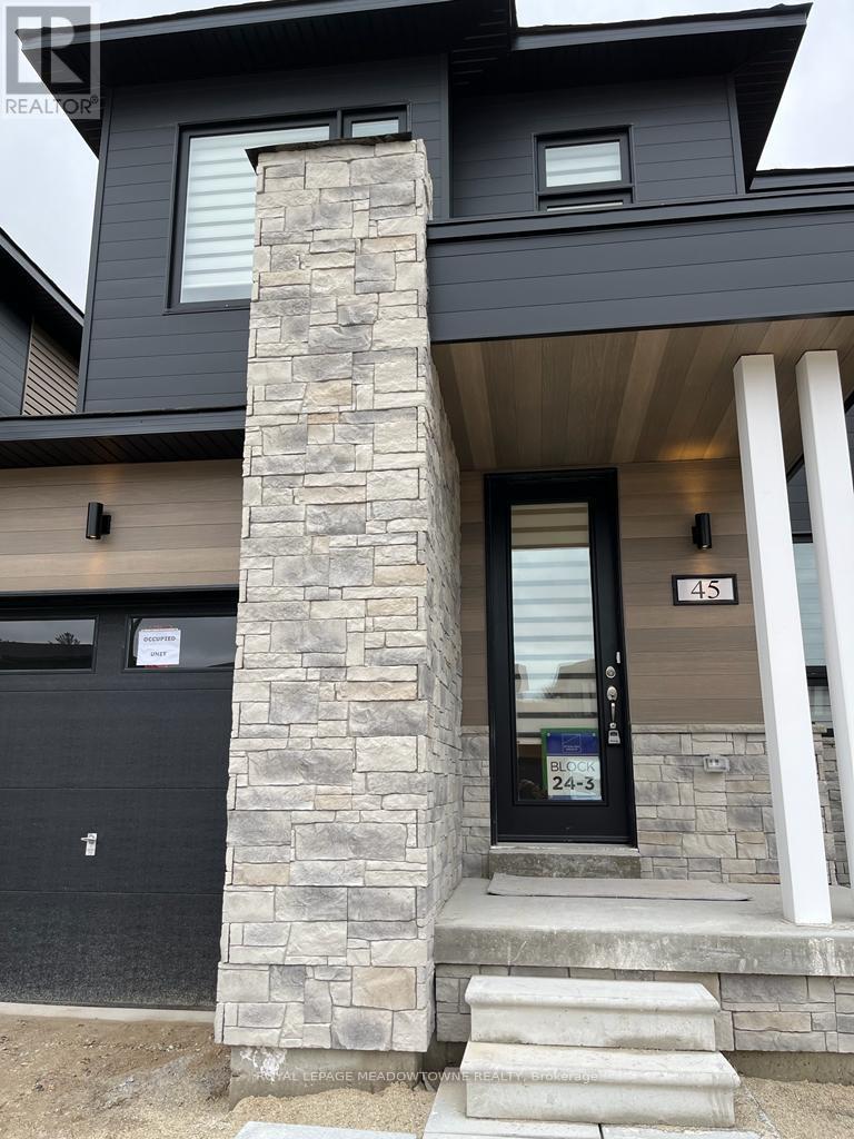 A modern house with a black door and a stone pillar in front.