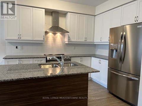 A kitchen with a granite counter top and stainless steel appliances.
