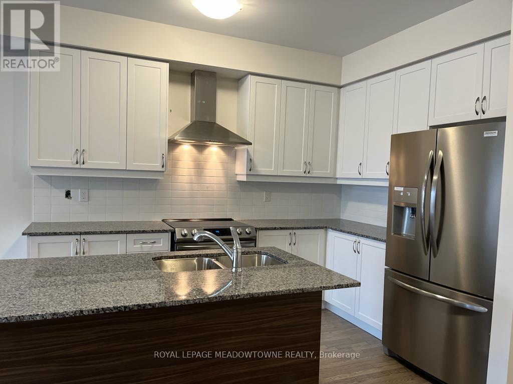 A kitchen with white cabinets and a stainless steel refrigerator.