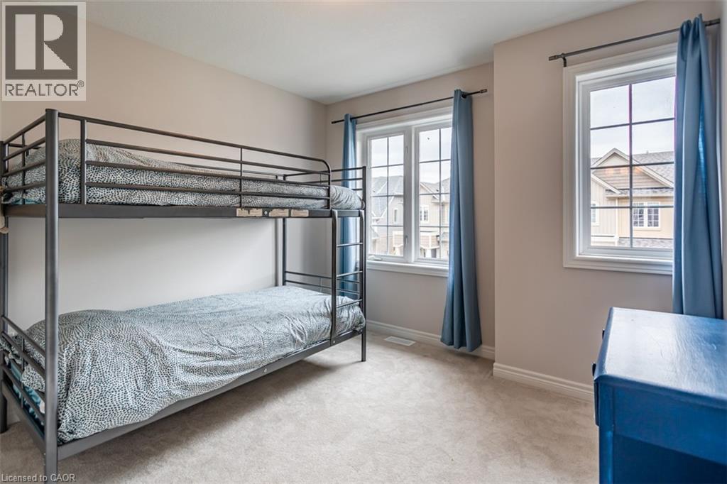 A bedroom with a bunk bed and a window with blue curtains.