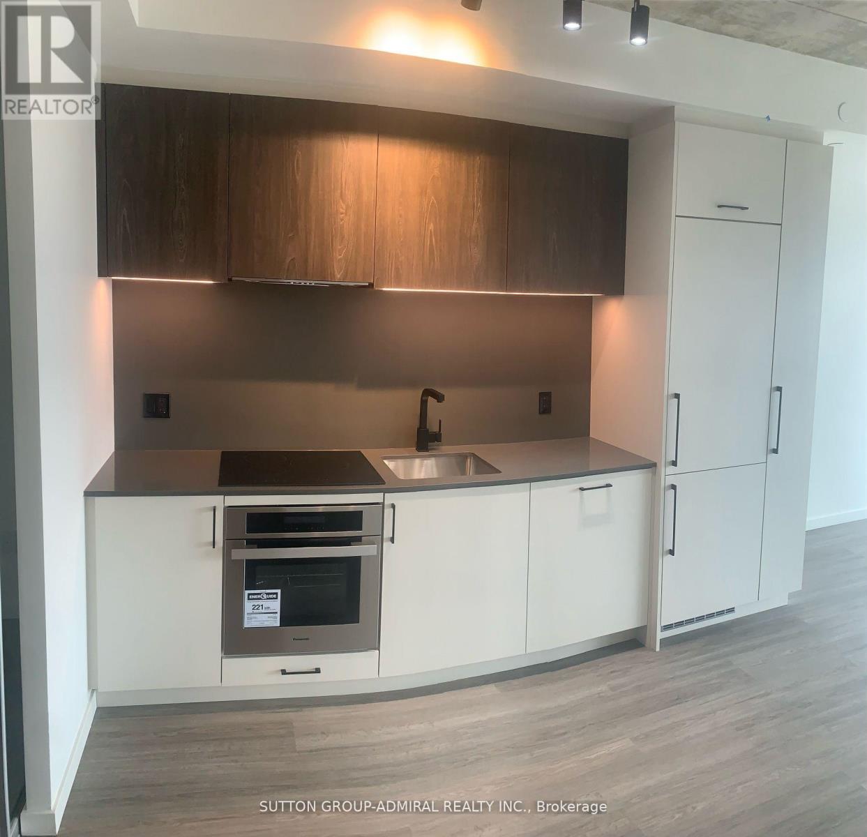 A kitchen with white cabinets and a wooden backsplash.
