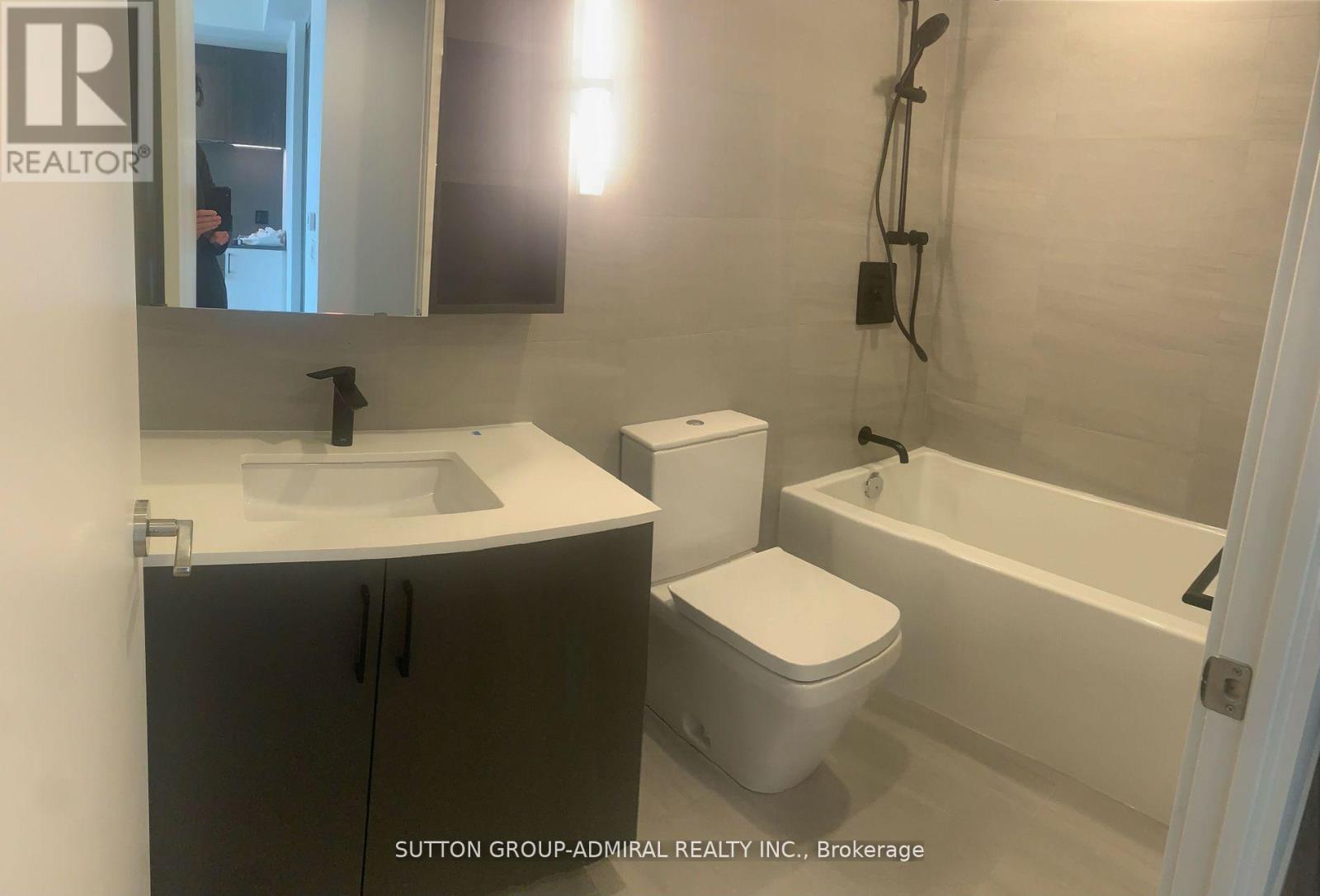A bathroom with a sink, toilet and bathtub.