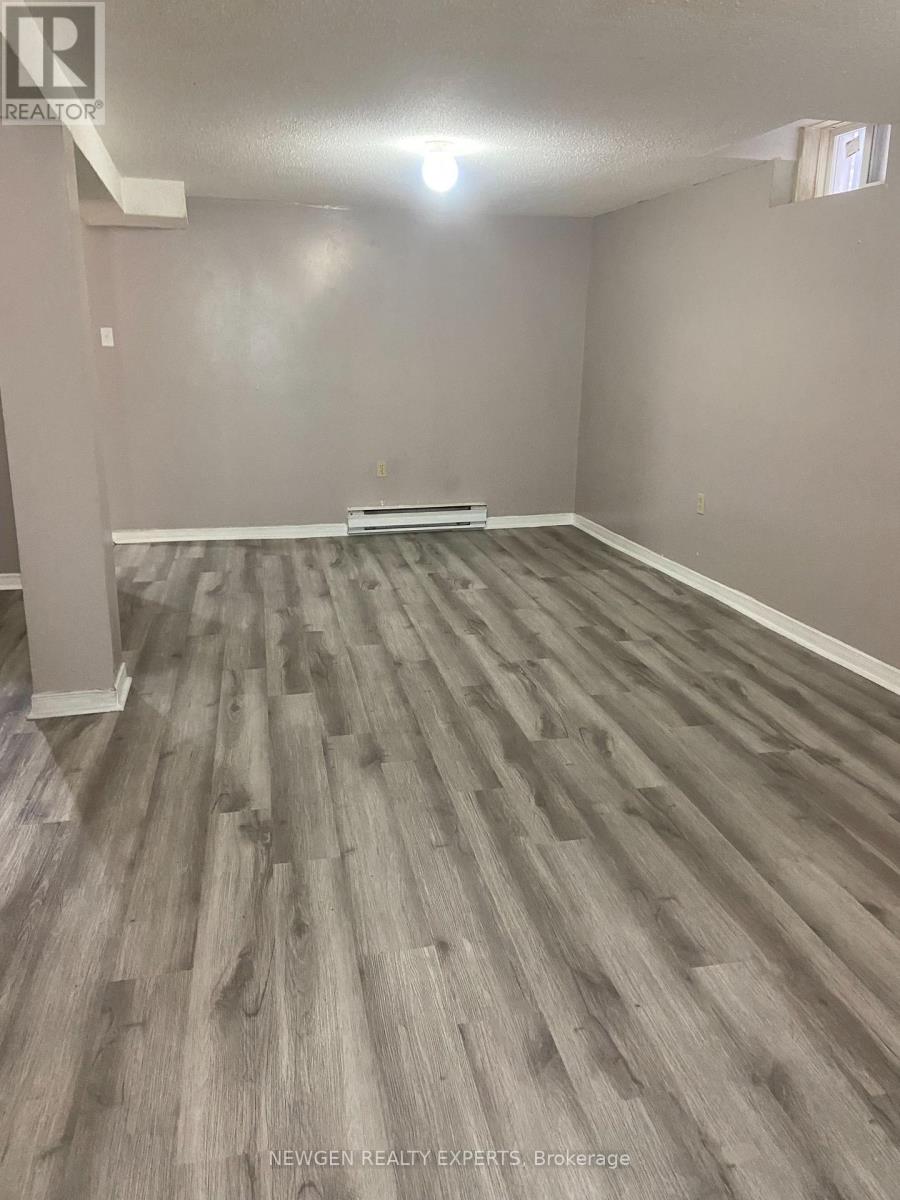 A room with wooden flooring and a white column in the corner.
