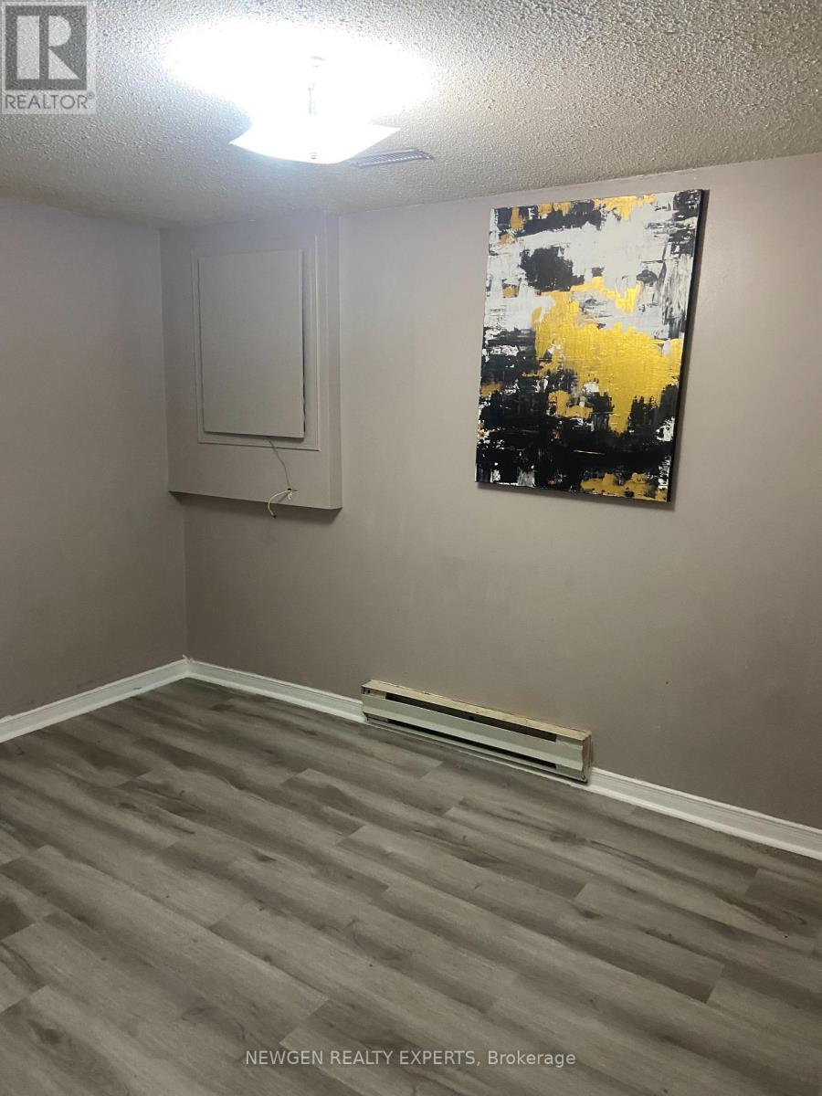 A room with a grey floor and a painting on the wall.