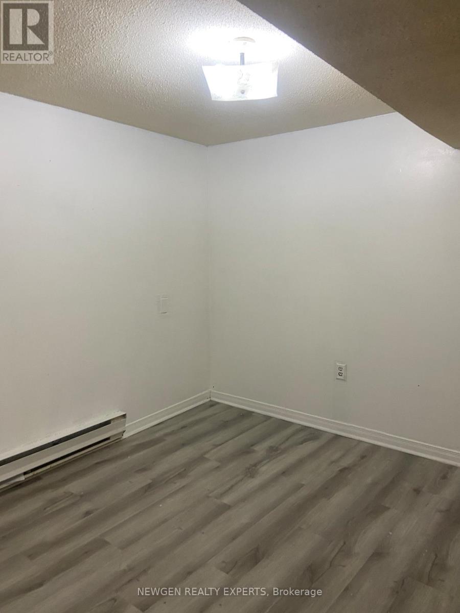 A room with wooden flooring and white walls.