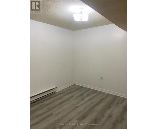 A room with wooden flooring and white walls.