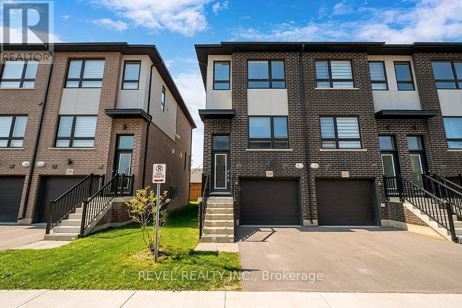 Two modern apartment buildings with garages and a no parking sign in front.