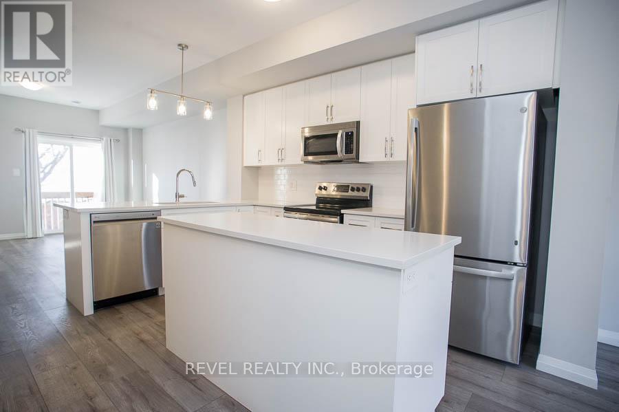 A modern kitchen with white cabinets and stainless steel appliances.