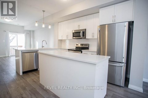 A modern kitchen with white cabinets and stainless steel appliances.