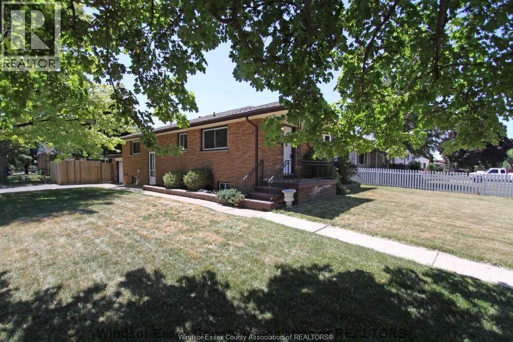 A house with a lawn and trees in front of it.