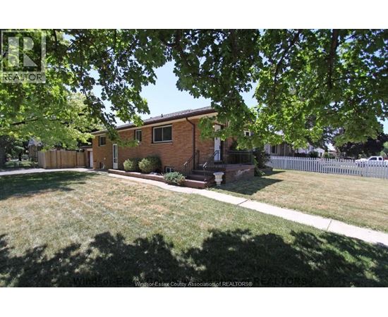 A house with a lawn and trees in front of it.