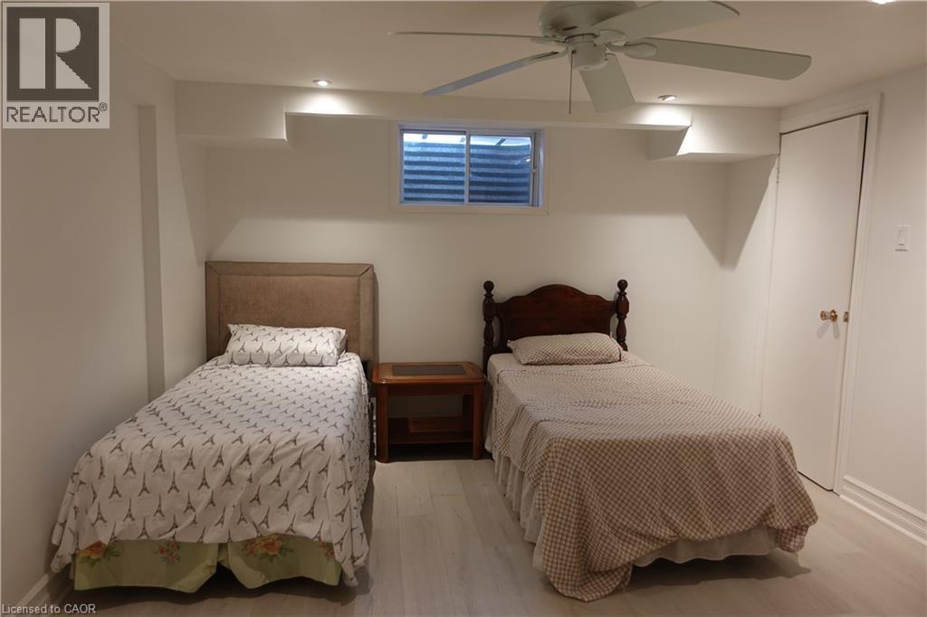 Two twin beds in a bedroom with a ceiling fan.