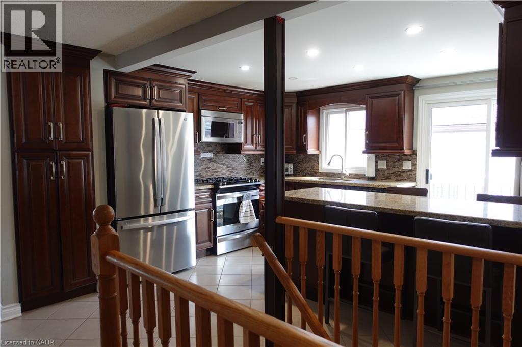 A kitchen with wooden cabinets and a stainless steel refrigerator.