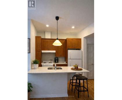 A kitchen with a white countertop and wooden cabinets.