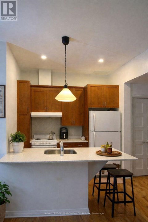 A kitchen with a white countertop and wooden cabinets.