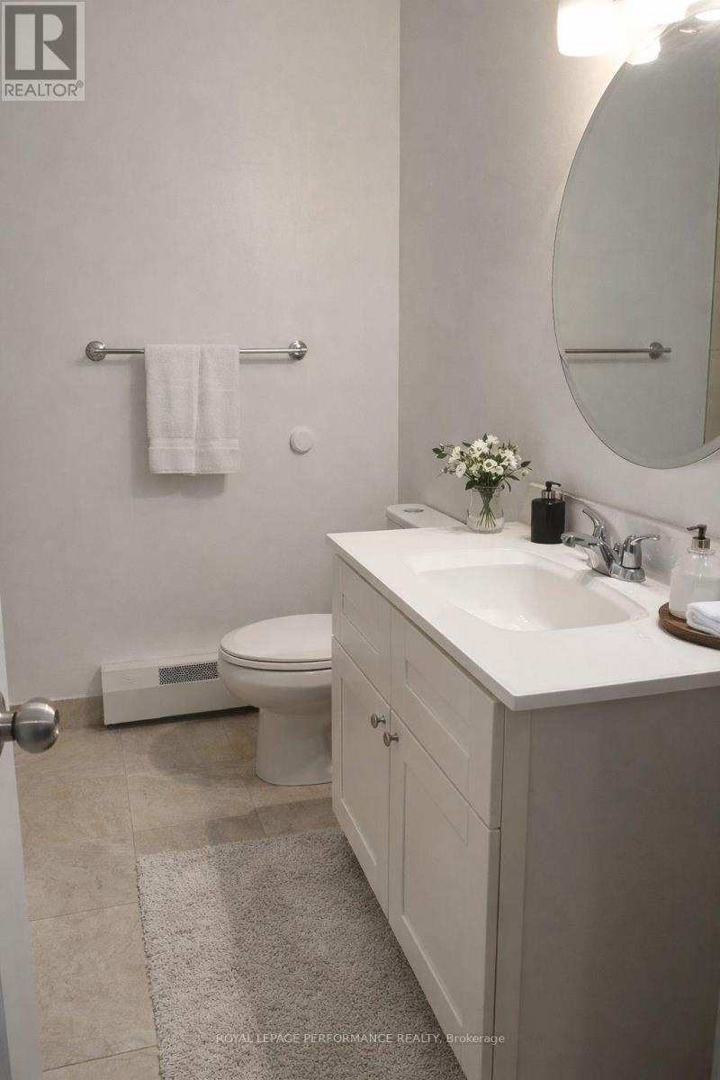 A white bathroom with a toilet, sink, and mirror.