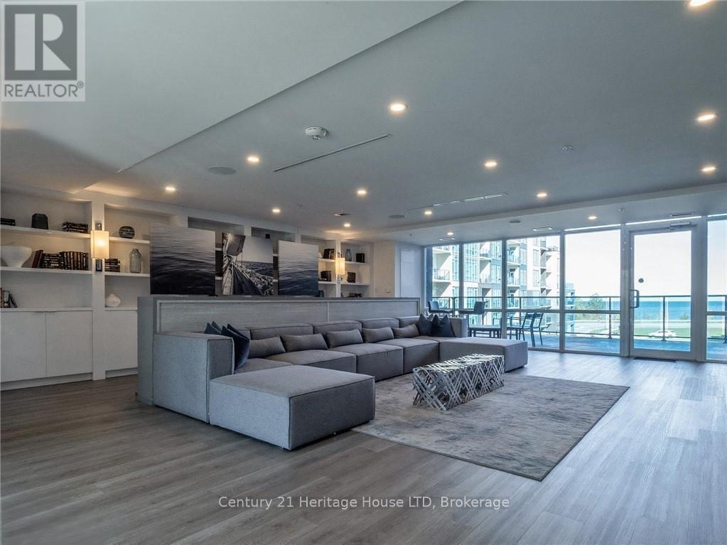 A modern living room with a grey sofa and a glass door leading to a balcony.