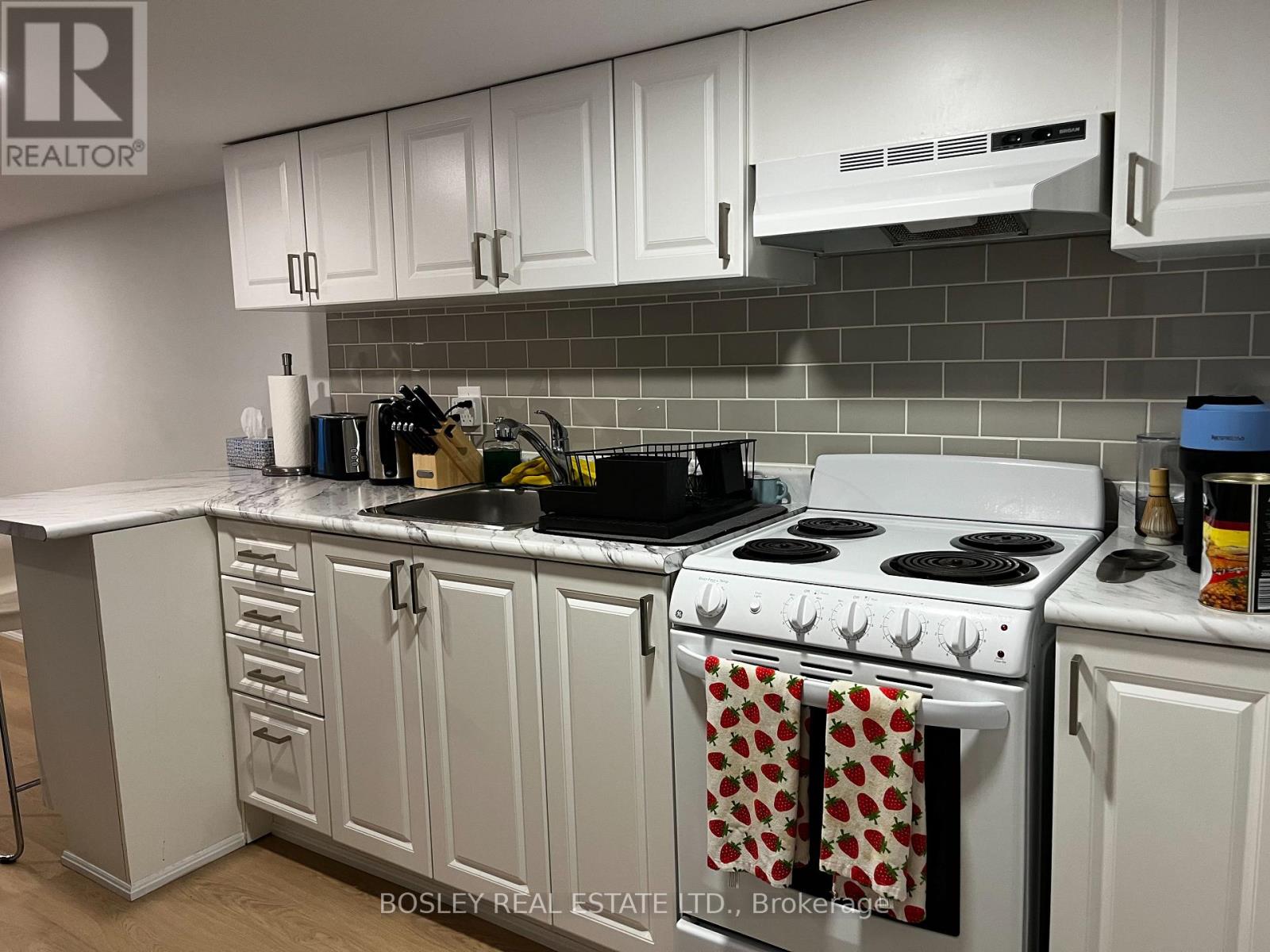 A kitchen with white cabinets and a white stove.