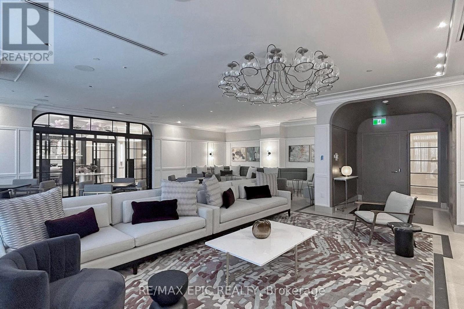 A living room with a white couch and a chandelier.