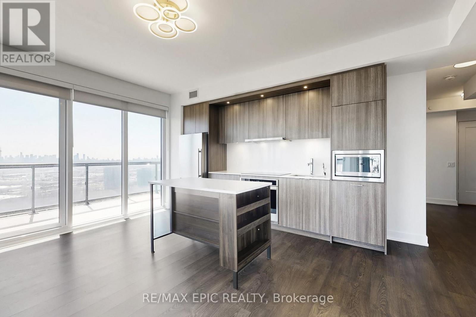A modern bedroom with a large bed and a balcony overlooking the city.