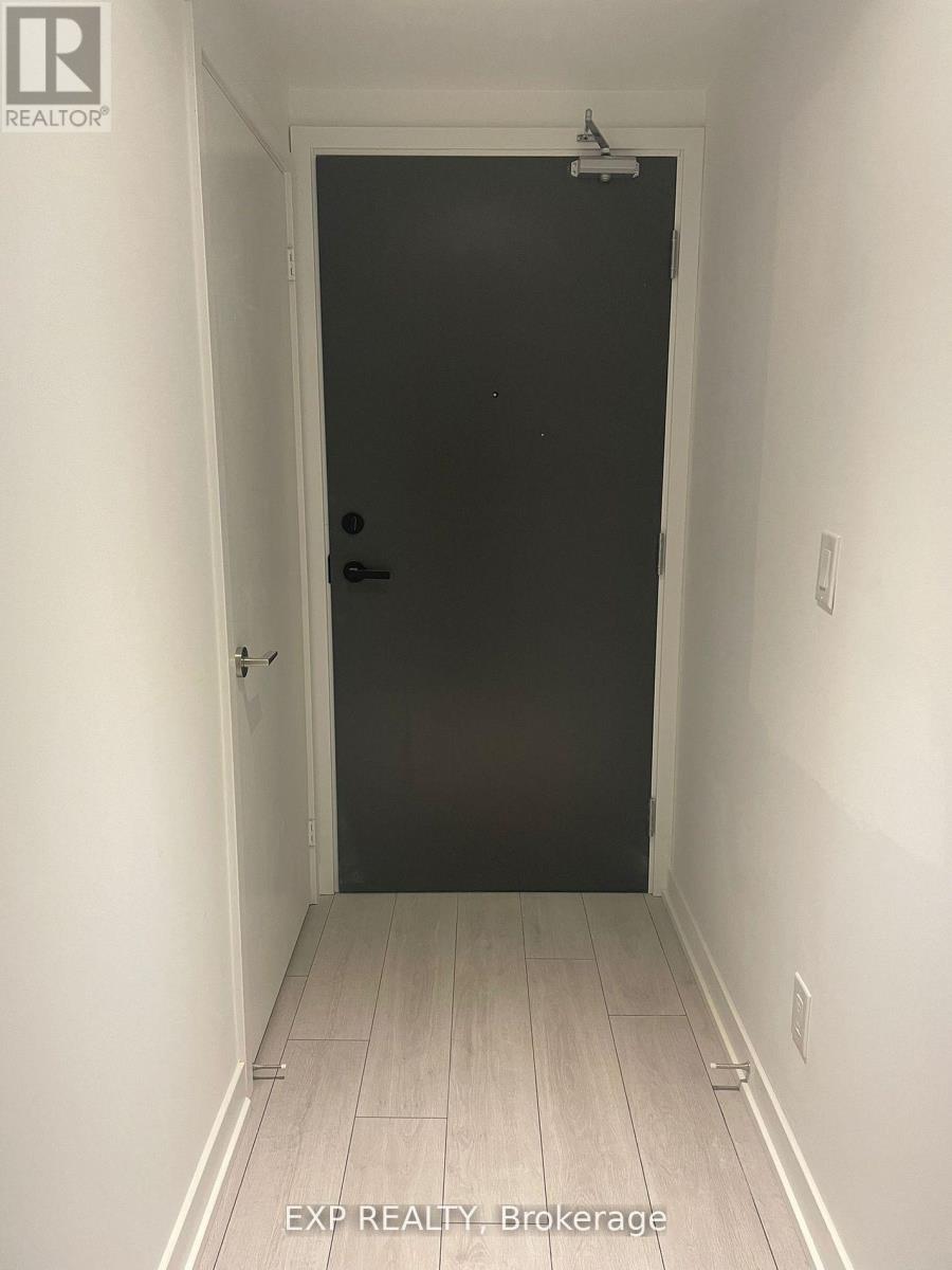 A black door in a white hallway.
