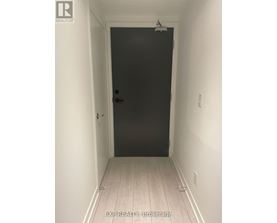 A black door in a white hallway.