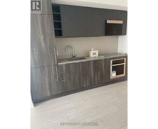 A modern kitchen with dark wood cabinets and a white countertop.