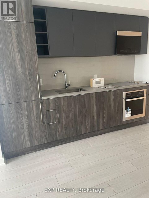 A modern kitchen with dark wood cabinets and a white countertop.