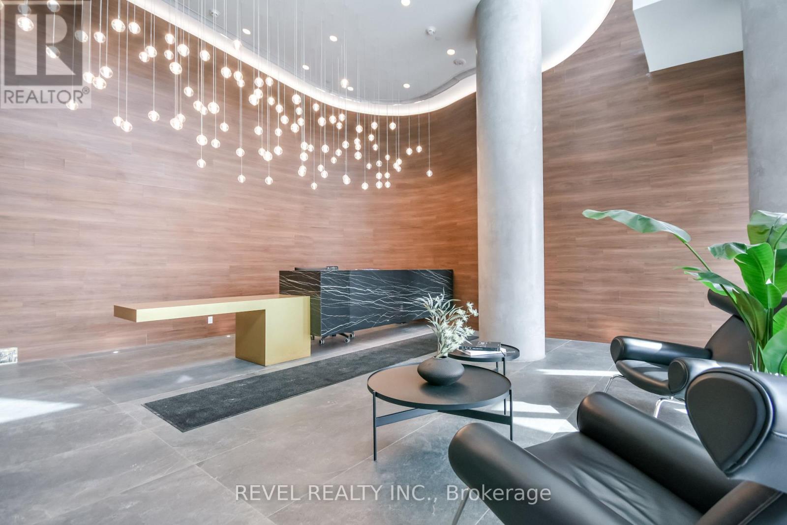 A modern living room with a black leather sofa and a wooden bench.