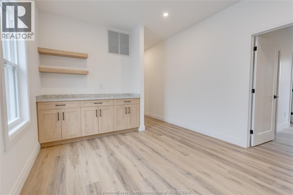 A spacious room with wooden flooring and a built-in countertop.