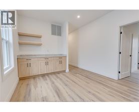A spacious room with wooden flooring and a built-in countertop.