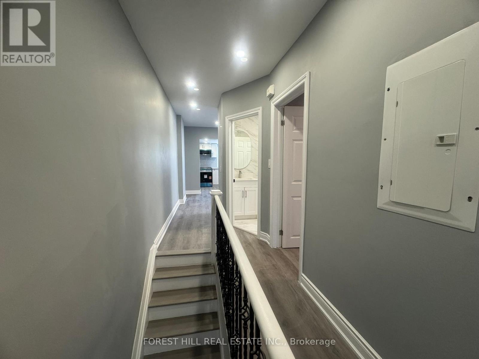 A hallway with a wooden floor and white walls.