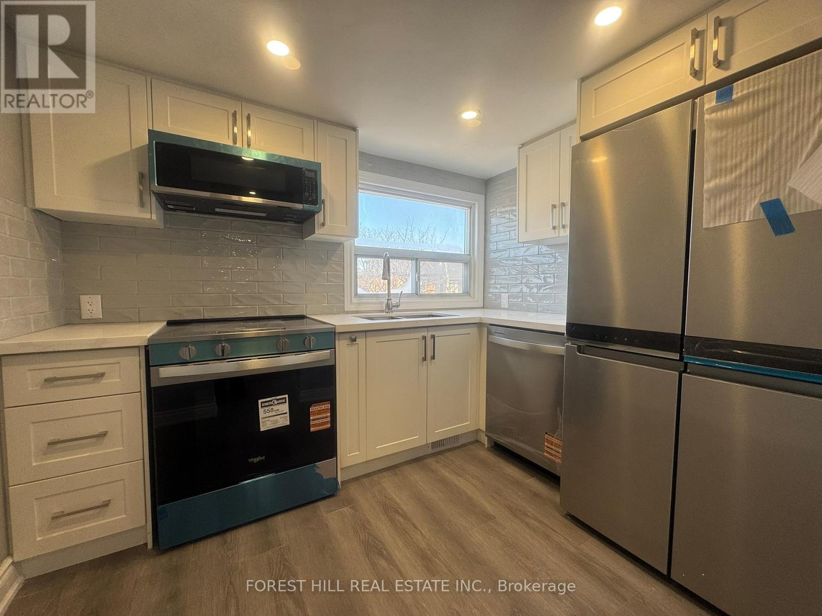A kitchen with a stove top oven and a refrigerator.