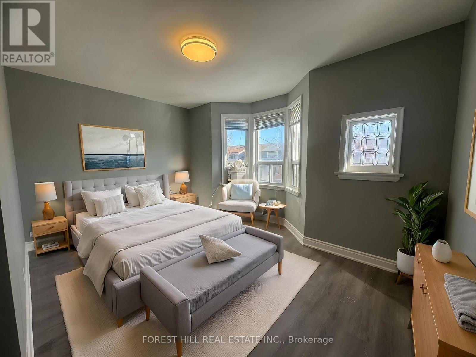 A bedroom with a large bed and a window overlooking a cityscape.