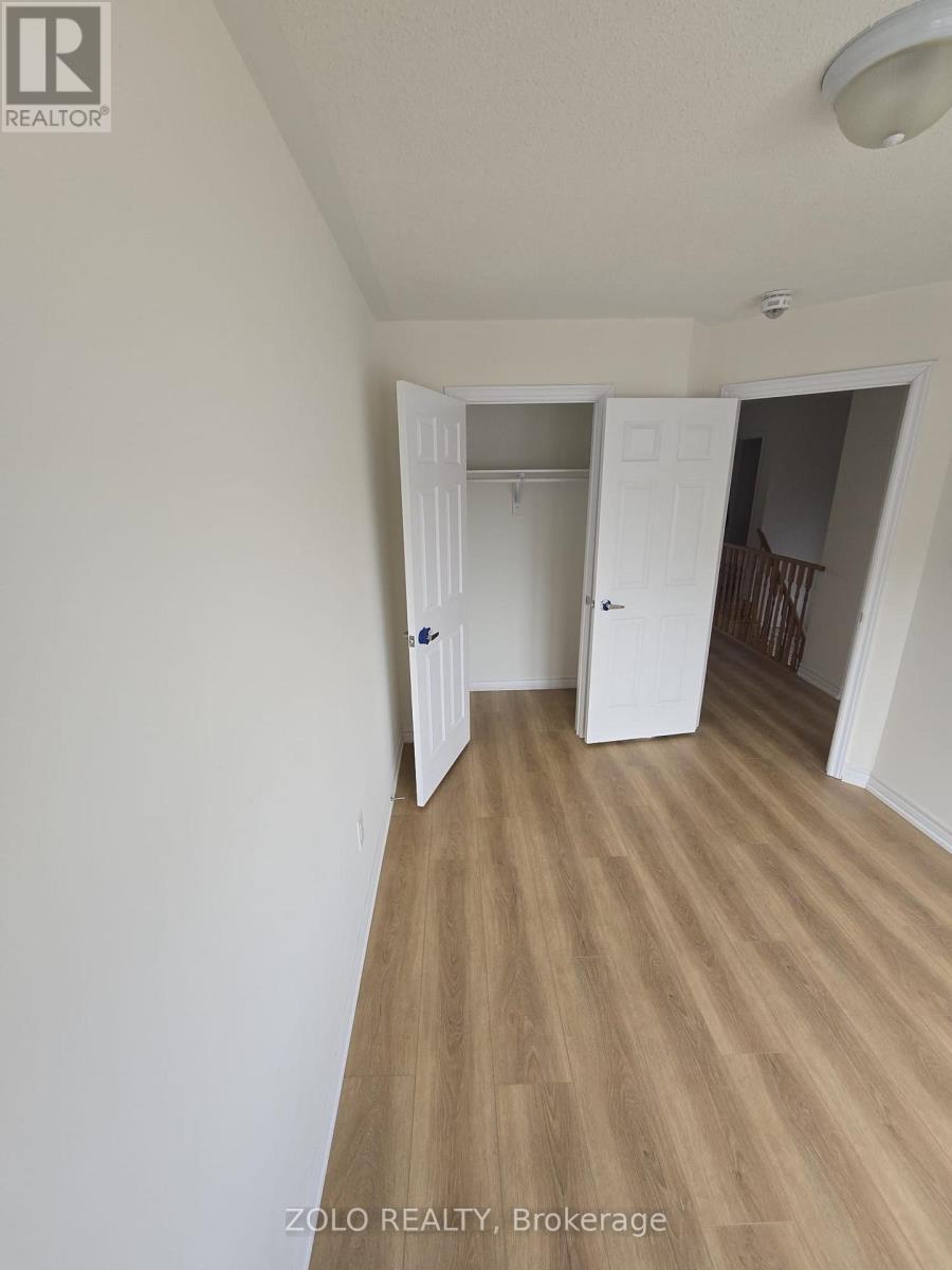 A room with a white door and a wooden floor.