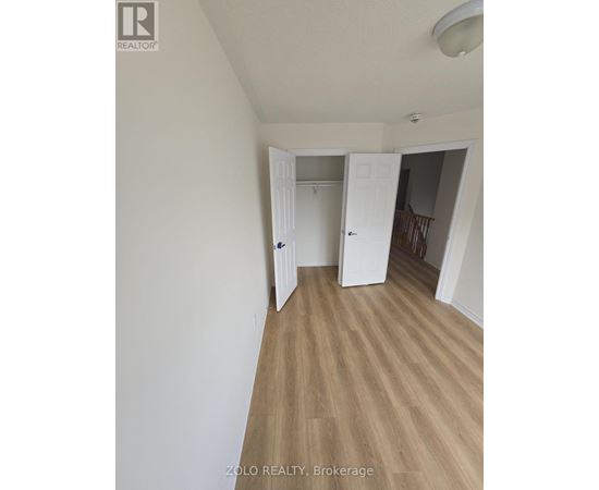A room with a white door and a wooden floor.