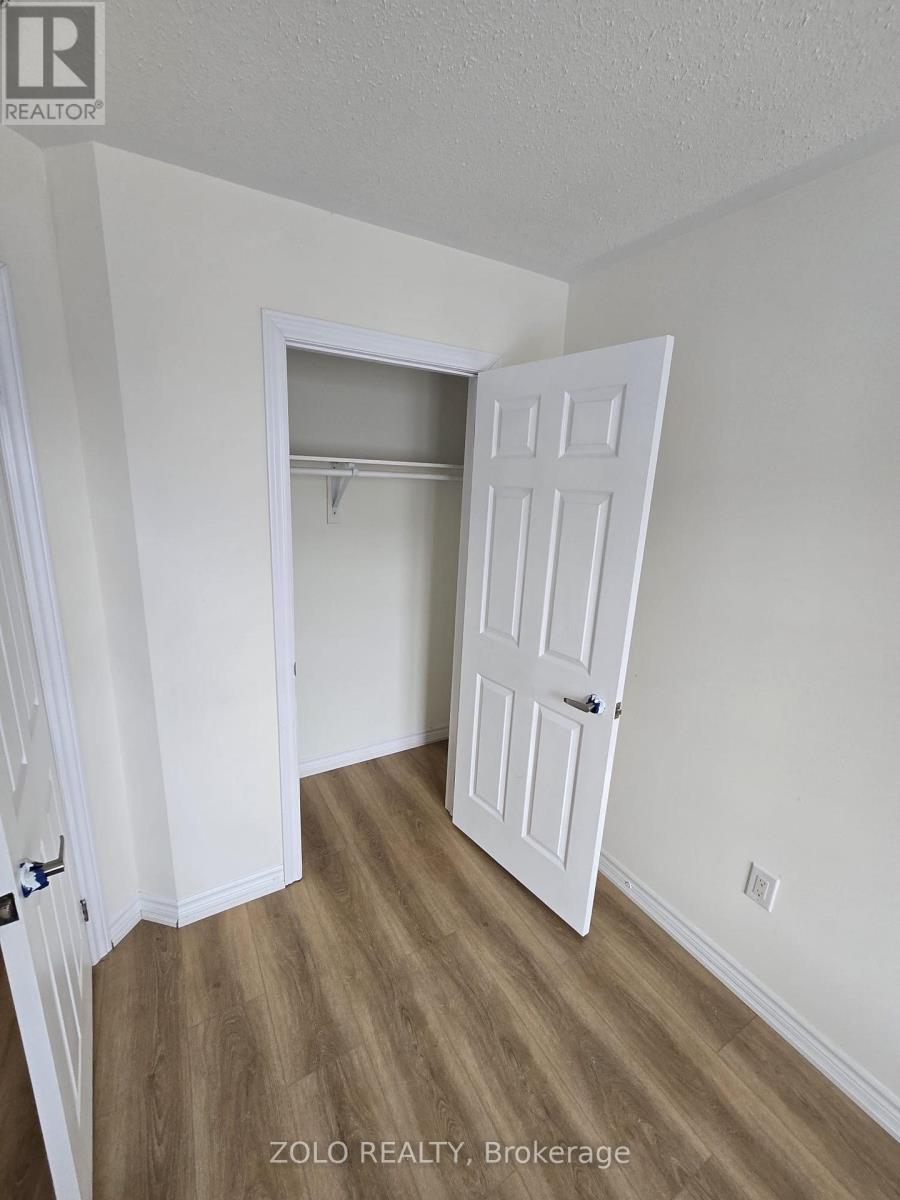A room with a white door and a wooden floor.