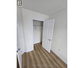 A room with a white door and a wooden floor.